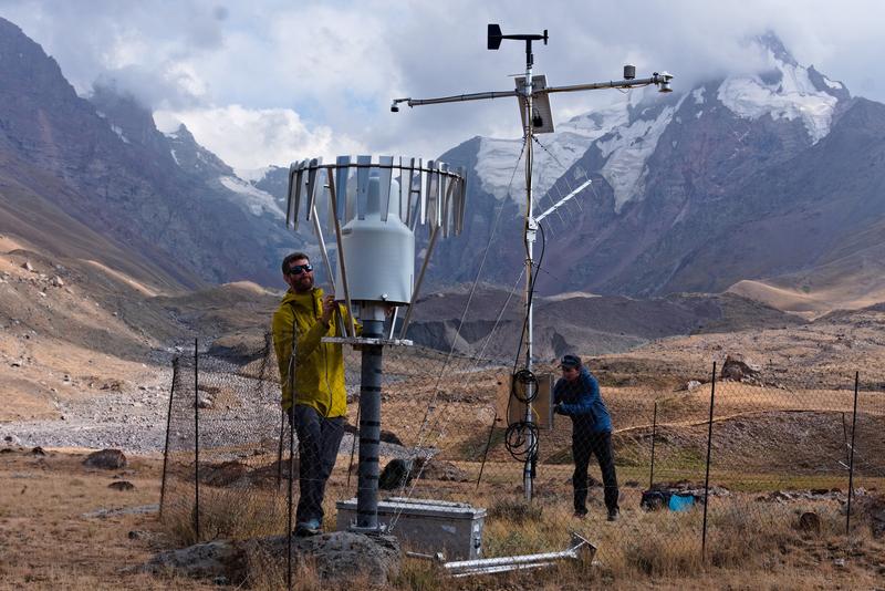 Wartung der Klimastation. Die Studienautoren Thomas Shaw und Achille Jouberton warten die Niederschlagsmessstation im Einzugsgebiet des Kyzylsu-Gletschers während ihres letzten Feldbesuchs im August 2025. Nordwestliches Pamir-Gebirge, Tadschikistan. 