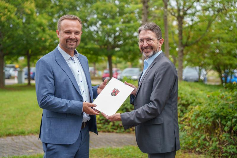 Vize-Präsident Prof. Dr.-Ing. Stephan Eder (rechts) übergibt die Bestellungsurkunde an Benedikt Blanz.