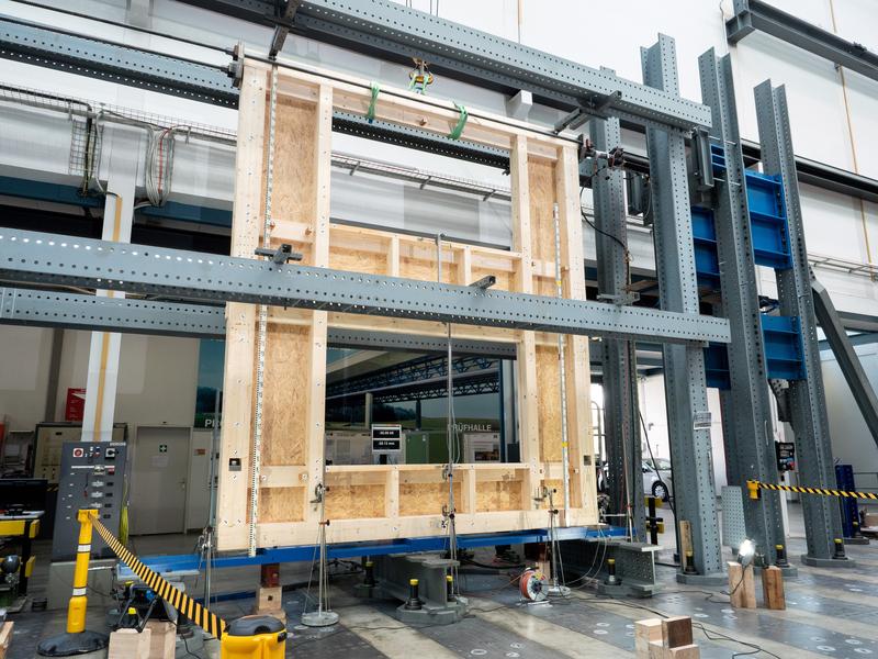 Eine zweigeschossige Hauswand mit Fensteröffnungen wird kontrolliert unter Druck gesetzt. Die Forschenden führten eine Reihe solcher Versuche an der Empa durch. Bild: Empa