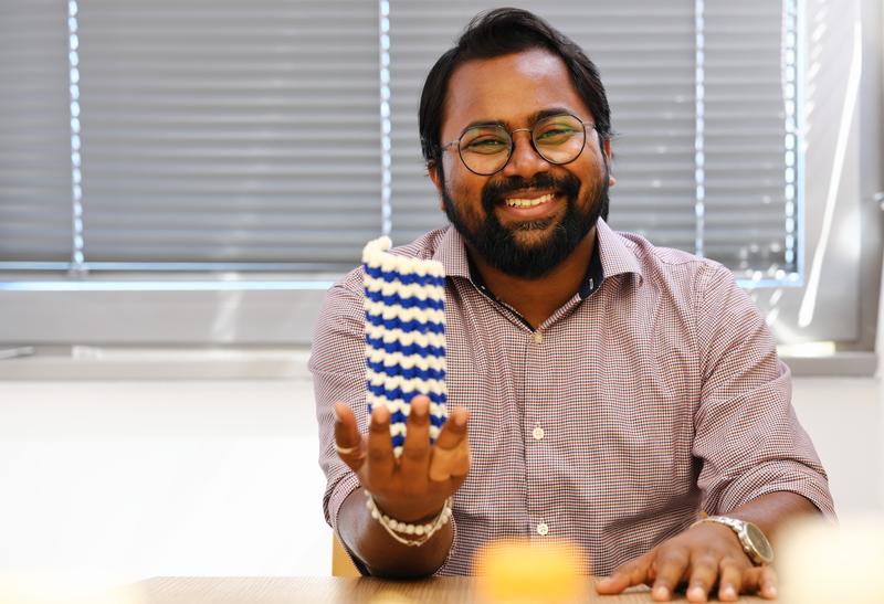 Doktorand Subham Biswas mit einem 3-D-Modell eines Mikrotubulus. Auf der Oberfläche des Röhrchens bewegen sich Motorproteine innerhalb von Zellen hin und her. Ein Protein namens Tau hilft dabei, die Oberfläche der Mikrotubuli instand zu halten. 