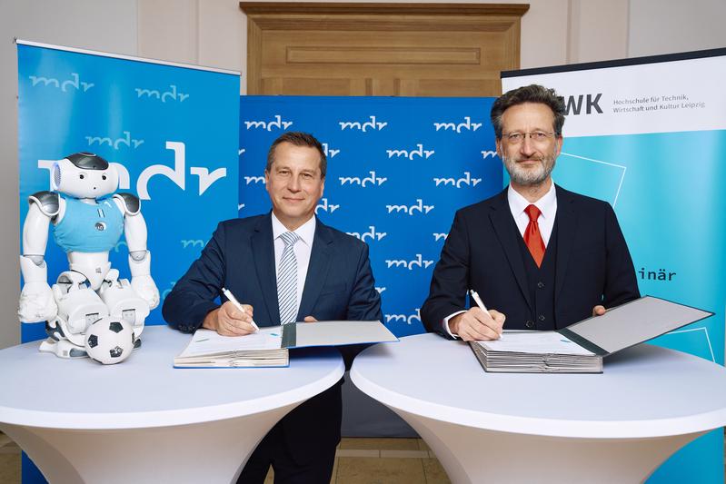 Ein Nao-Roboter des Teams "HTWK Robots" stand Pate bei der Unterzeichnung des Kooperationsvertrages der HTWK Leipzig mit dem MDR: v. l. MDR-Intendant Ralf Ludwig und HTWK-Rektor Prof. Dr.-Ing. Jean-Alexander Müller. 