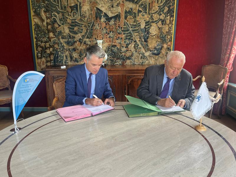 Alain Mérieux (r.) und Philippe Gréciano (l.) unterschreiben den Kooperationsvertrag zum „One-Health-Preis 2026“