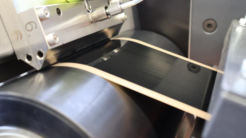 Katalysator-Tinte wird über eine Schlitzdüse kontinuierlich auf eine Transferfolie aufgetragen. 