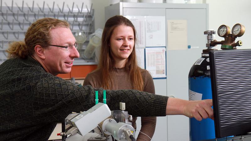 Professor Marcel Deponte und Laura Leiskau an einem Stopped-Flow-Spektrofluorometer, wie es bei der Forschungsarbeit zum Einsatz kam.
