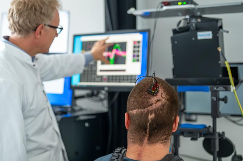     Prof. Simon Jacob und Studienteilnehmer Michael Mehringer besprechen Daten, die über eine Hirn-Computer-Schnittstelle gewonnen wurden.