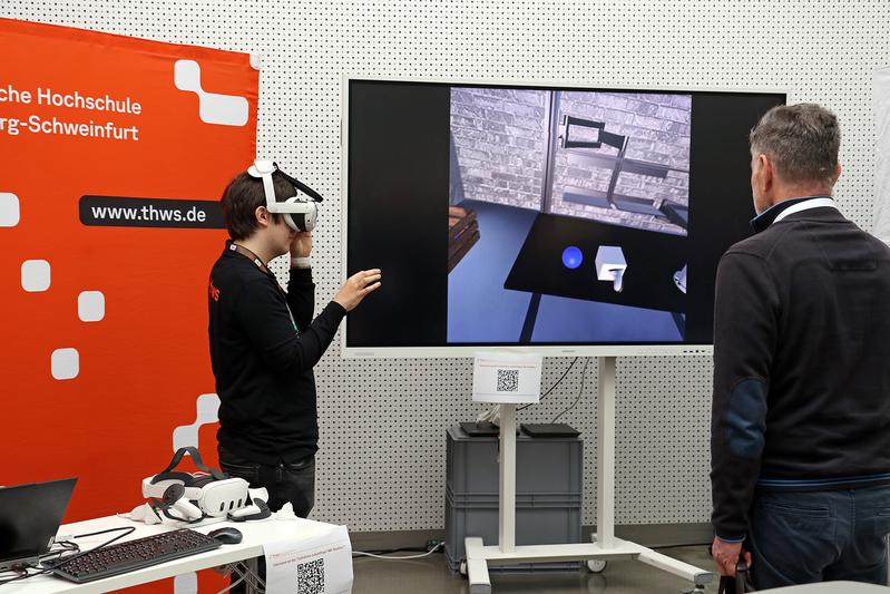 Doktorand Silvio Lang (li.) demonstriert die virtuelle Montage mit MR-Brille, gesteuert durch Handgesten