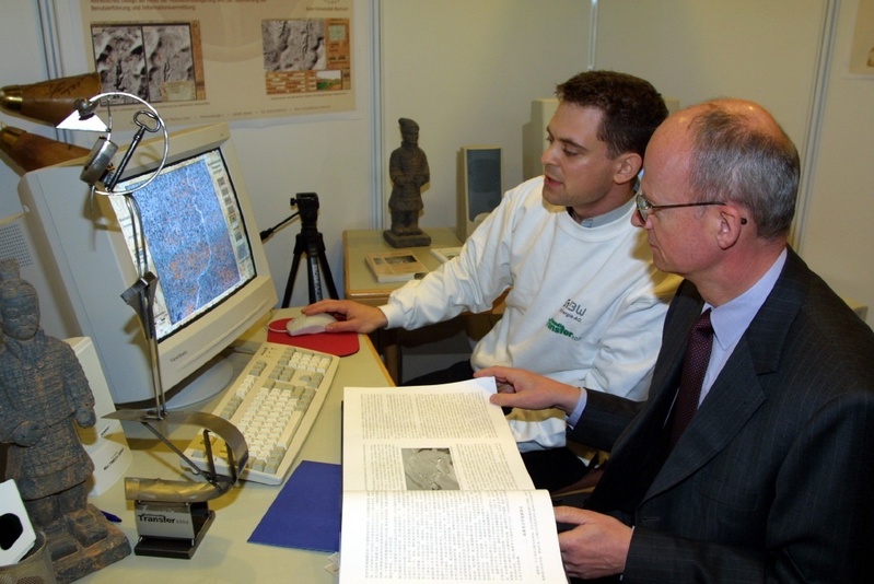 Erklärt sein Informationssystem dem baden-württembergischen Wissenschaftsminster Prof. Dr. Peter Frankenberg auf der Learntec: RUB-Geograph Markus Oster (links)