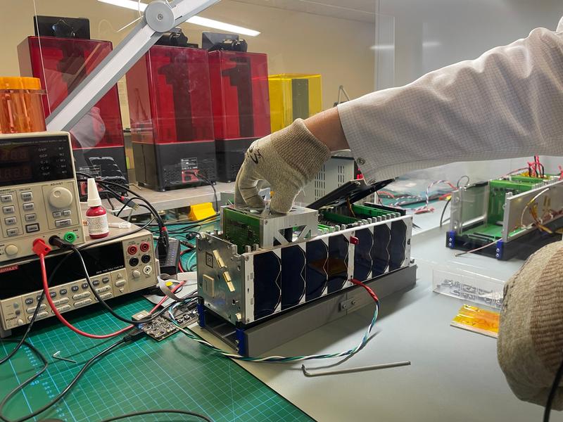 ADCS-Box (Attitude Determination and Control System) während des Einsetzens in das Qualifikationsmodell des InnoCube-Satelliten