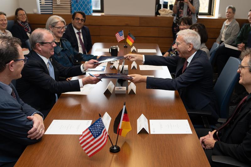 Der Chancellor der University of Kansas, Douglas A. Girod (li.), und der Präsident der Universität Regensburg, Udo Hebel, tauschen unterzeichnete Dokumente aus, mit denen die umfassende Partnerschaft zwischen der KU und der UR formalisiert wird.