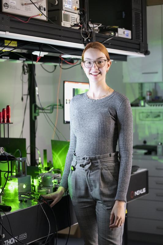 ISTA PhD student Andrea Stöllner in front of her experimental setup. Beyond the lab, the physicist and “cloud scientist” finds relaxation in yoga, baking, and playing the flute in an orchestra.