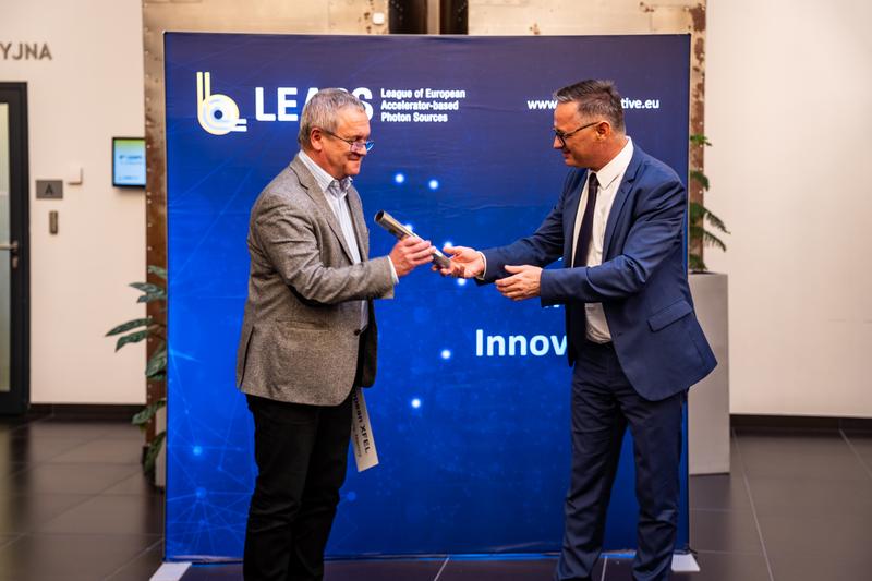 Prof. Serguei Molodtsov, Scientific Director of European XFEL, accepts the symbolic chairmanship baton on Thomas Feurer's behalf.