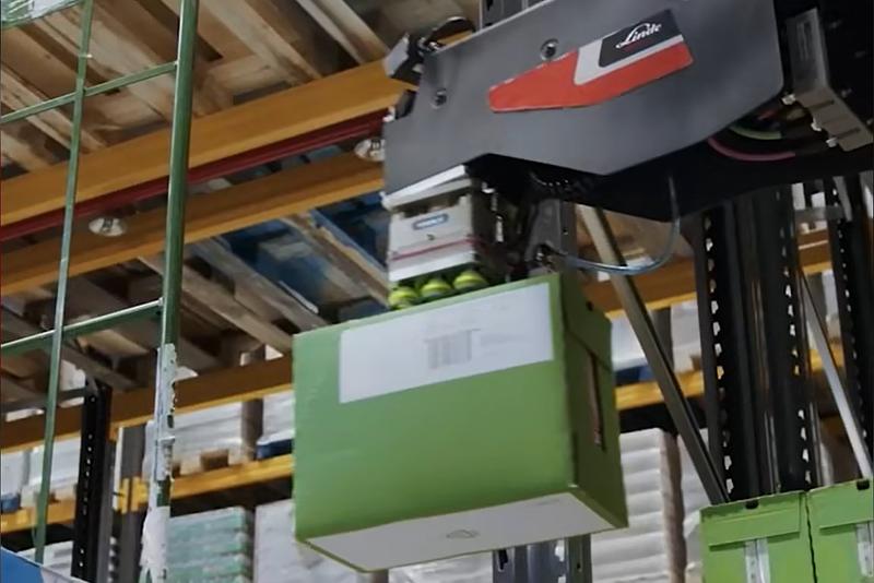 Pakete werden mit einem Sauggreifer aus dem Regal gehoben