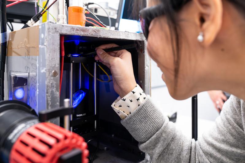 The study’s first author, ISTA PhD student Sue Shi, places a particle inside the acoustic levitation setup. 
