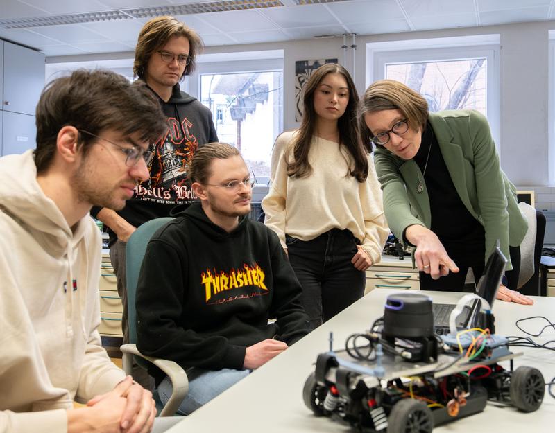 Prof. Dr.-Ing. Christina Singer mit Studierenden im Projekt „DriveOhm“. Dabei werden unter anderem im Modellmaßstab automatisierte Rennfahrzeuge erstellt und erprobt. 
