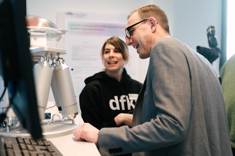 DFKI-Wissenschaftlerin Natascha Koch erläutert Digitalisierungsminister Schrödter ihre aktuelle Forschungsarbeit