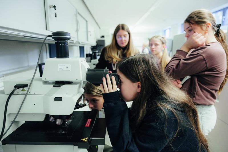 Mit dem Lichtmikroskop am Fraunhofer IISB verfolgen Schülerinnen der Montessori Schule Herzogenaurach in Echtzeit das Wachstum von Mikrokristallen aus einer gesättigten KaliAlaun-Lösung.