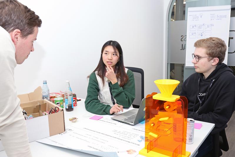 Thuyvy (Mitte) von der Fakultät Gestaltung der THWS und Oliver (re.) von der Universität Würzburg bereiten den Pitch für „SLOMA“ vor – Kaffeegenuss auf die langsame Art