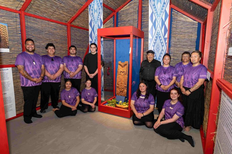 Delegation aus der Uawa-Bucht in der Ausstellung auf Schloss Hohentübingen. Victor Walker in schwarz rechts neben dem Pou.