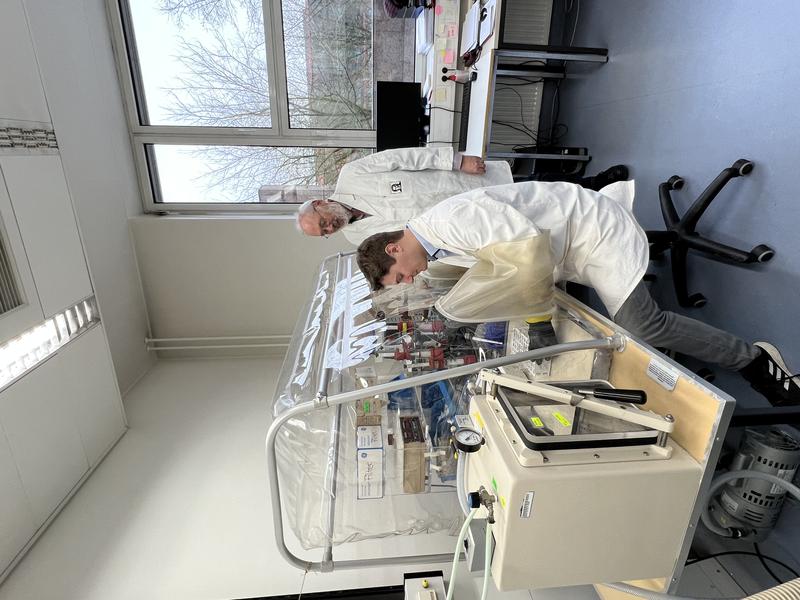 In the lab: Raphael Trischler (seated) and Volker Müller in the laboratory at an anaerobic chamber. The chamber contains no oxygen but nitrogen, allowing oxygen-sensitive bacteria such as B. luti to be handled safely. 