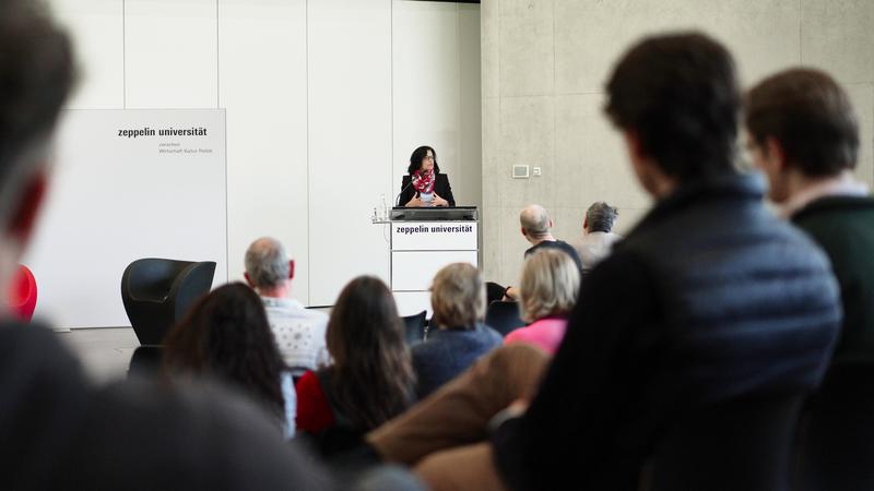 Prof. Dr. Anja Achtziger hält eine Ansprache im Graf-vom-Soden-Forum der Zeppelin Universität, wo die Amtseinführung zusammen mit der Studierenden, Lehrenden, Forschenden und Verwaltungsmitarbeitenden stattgefunden hat.