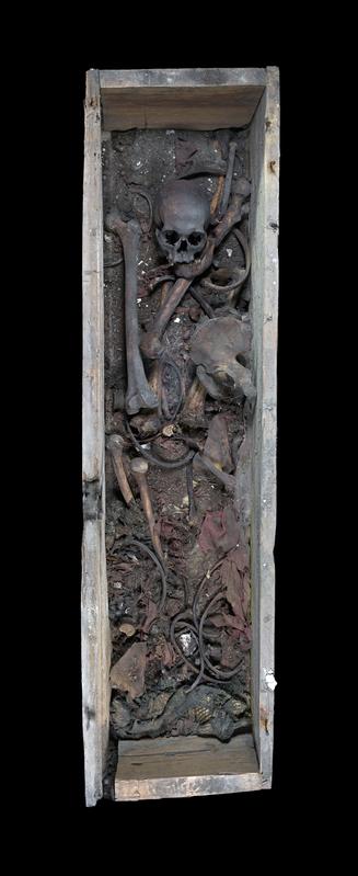 View inside the open wooden coffin containing the human remains of Otto I, textiles, and sediment.