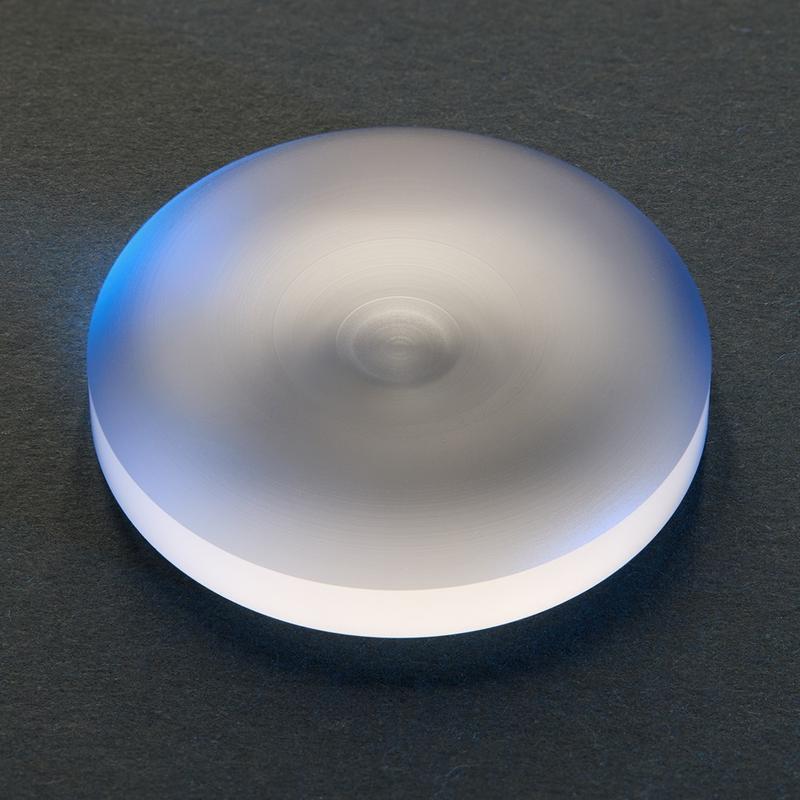 An aspheric gullwing lens with a diameter of 40 mm, after laser-based shaping and before polishing.