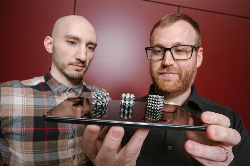 Doctoral research students Thorben Trodler (left) and Michael Fries (right) are involved in the optimization of these delicate heat-exchange structures made from nickel-titanium alloy, through which air and water can flow.