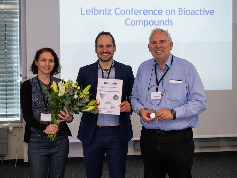 Award ceremony in Aachen: Pierre Stallforth (center) receives the certificate for the Leibniz Drug of the Year 2026 from Yvonne Mast and Ludger Wessjohann, both spokespersons of the Leibniz Research Network “Bioactive Compounds”.