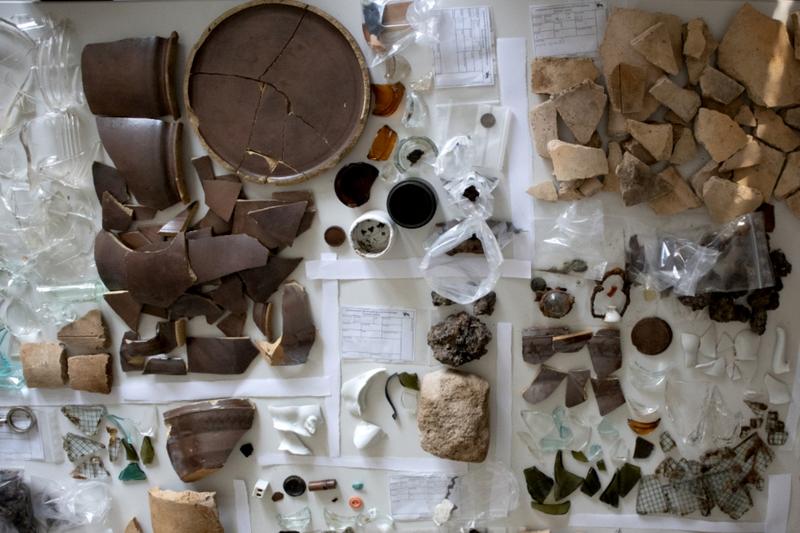 Überblick über das Fundmaterial aus einem Schnitt, darunter typische Keramik-, Glas- und Bakelitobjekte.