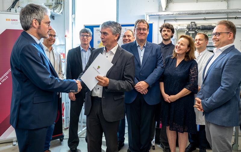 Staatssekretär Dr. Steffen Eichner übergibt Dr. Felix Glahn den Fördermittelbescheid.