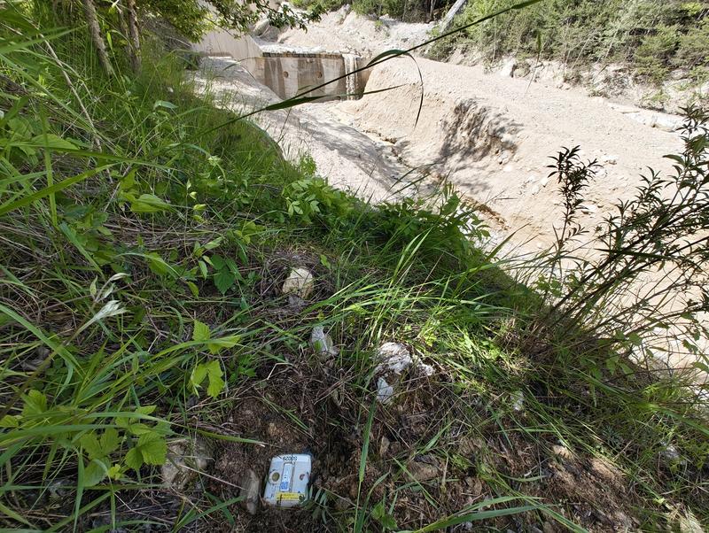 Buried geophones along the Illgraben with check dam in the background.