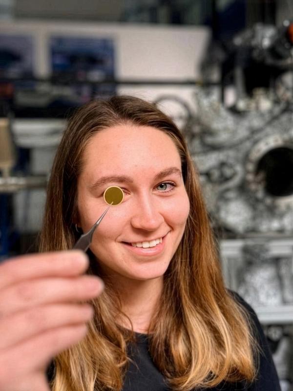 Martina Fellinger mit dem Grundbaustein für die Präzisionswaage: Ein 14 mm großes Quarzscheibchen mit Gold-Elektroden.