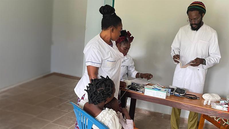 Treatment of a patient at the CERMEL satellite site in Mighoma, Tchibanga, as part of the clinical SPAP study in Gabon. Pictured are nurse Merleye Nongou (standing), data clerk Naomie Badinga (seated), and physician Dr. Alex Hounmenou Zinsou.