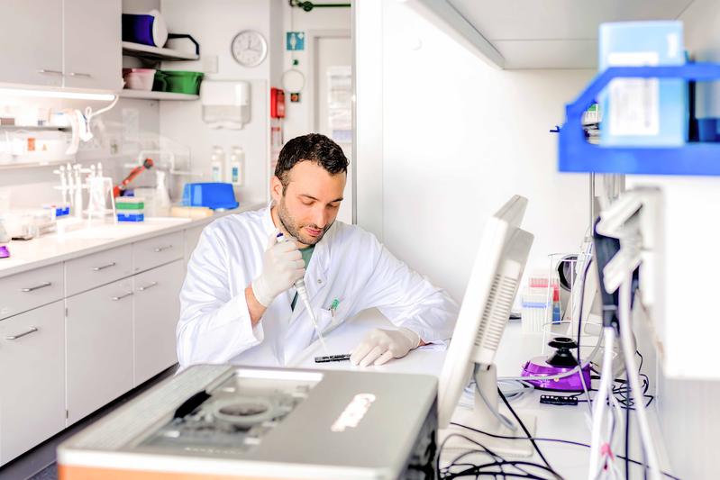 Dr. Micha Banz bei der Vorbereitung einer Sequenzierbibliothek: Mit der Pipette wird eine aufgereinigte DNA-Probe für die Analyse auf eine Sequenziereinheit aufgebracht.