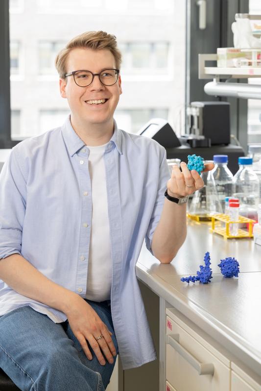 Dr. Mike Blüggel, Leiter der Nachwuchsgruppe Funktionelle Biochemie am Zentrum für Medizinische Biotechnologie der Universität Duisburg-Essen, zeigt ein 3D-gedrucktes Modell des Anti-Taspase1-Nanobodys.