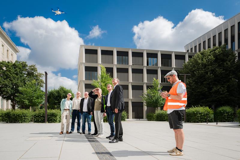 Vermessungsingenieur Fabian Ettelt (HTWD) startet eine von der HTWD entwickelte Drohne. V.l.n.r.: Dr. Robert Reiß (LfA), Thomas Reuter (LfA), Markus Strothteicher (LfA), Prof. Stephan Kopf (HTWD), Dr. Regina Smolnik (LfA), Prof. Danilo Schneider (HTWD)