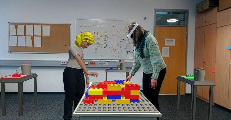 Zwei Personen, die sich an unterschiedlichen Orten befinden, bauen mit Hilfe des im Projekt Co-Humanics entwickelten Augmented Reality-Systems gemeinsam ein virtuelles Haus aus Legosteinen