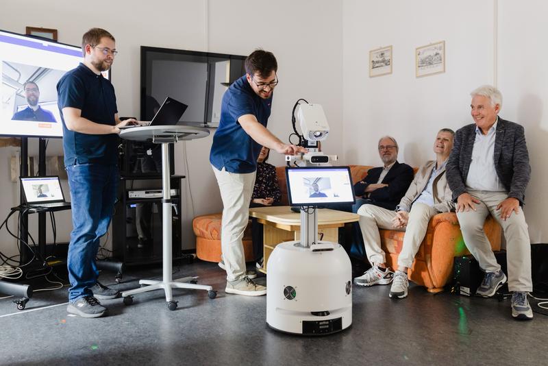 Roboter Robby mit den Teilprojektleitern des Co-Humanics-Projekts Prof. Horst-Michael Groß, Prof. Wolfgang Broll und Prof. Karlheinz Brandenburg sowie Söhnke Fischedick, M.Sc. und Kay Richter, M.Sc. vom Fachgebiet Neuroinformatik und Kognitive Robotik