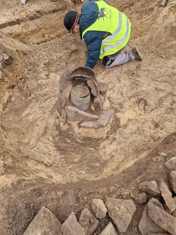 Groß Rosenburg. Ausgrabung eines Urnengrabs mit Steinschutz. 