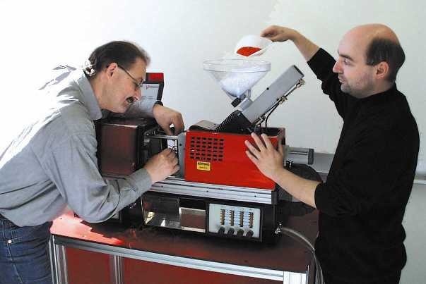 von links: Dr. Albert Otten und Dipl.-Ing. Till Joachim richten die Spritzgießmaschine 'Babyplast' für die Kunststoffverarbeitung ein.