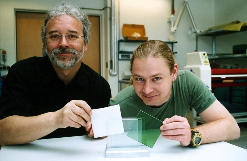 Das Schichtprinzip der Sandwich-Bauweise für Brandschutzgläser demonstrieren Prof. Dr. Gerhard Meyer (l.) und Student Nicolas Wirth: Zwischen die glasklaren Scheiben kommen Funktionsschichten, die im Brandfall beispielsweise aufschäumen. Foto: FHG/BL