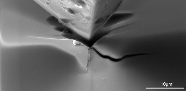 Aufnahme unter dem Rasterelektronenmikroskop: Die Empa-Forscher untersuchten mit einer feinen Diamantpyramide, dem Nanoindentor (von engl. intend: eindrücken), wie die Risse beim Ritzen von Silizium-Wafers entstehen. 