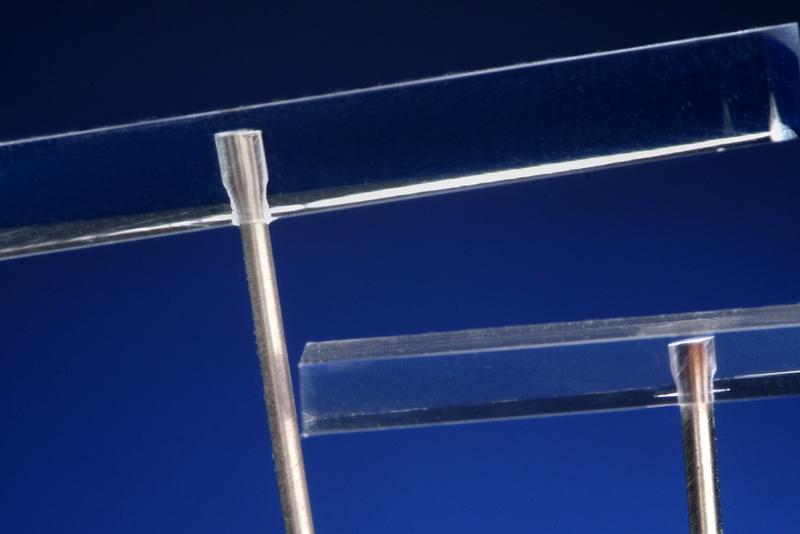Über einen Laserstrahl können Metallbügel fest mit Kunststoffen, etwa Brillengläsern, verbunden werden.