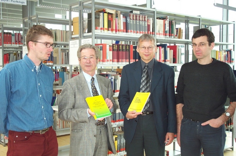 Prof. Meyer (2.v.l.) übergibt sein neues Buch an den Prorektor des Bereiches Wirtschaft der Hochschule Prof. Kurz (2.v.r.)