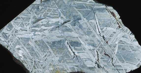 Der Eisenmeteorit "Joe Wright Mountain" (die vertikale Bildkante entspricht 8,3 Zentimetern). Durch das Anätzen der polierten Fläche wurden die typischen so genannten "Wiedmannstättenschen Figuren" sichtbar. Foto: Kelber
