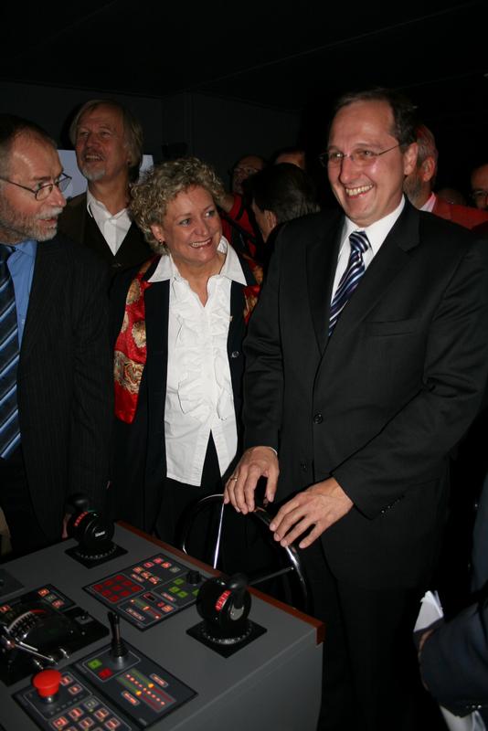 (von links). FH -Dozent Günter Schmidt, der SPD- Bundestagsabgeordnete Dr. Wolfgang Wodarg, Susanne Herold, MdL, Bildungspolitische Sprecherin der CDU-Landtagsfraktion und Wissenschaftsstaatsekretär Jost de Jager, CDU. am Ruder des neuen Brückensimulators der FH Flensburg