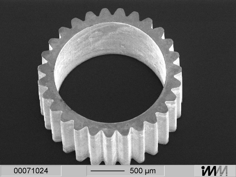 Rasterelektronenmikroskopische Aufnahme eines mikrostrukturierten Zahnrads: Die saubere Oberfläche der metallenen Struktur ist vollständig von SU-8 Fotolack gereinigt.