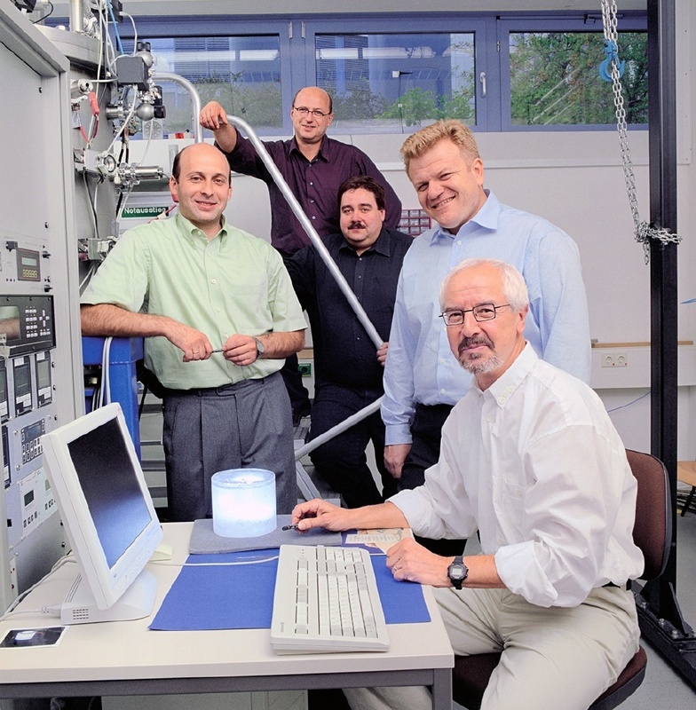 Die Stifterverbandspreisträger, hier ohne ihre Kollegen von SCHOTT, versammeln sich um einen Kristallzylinder: Alexander Molchanov, Dr. Jochen Friedrich, Oliver Gräbner, Gheorghe Ardelean und Prof. Georg Müller (von links). © Fraunhofer