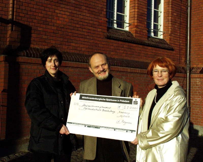 Prof. Dr. Rainer Janisch, Präsident der FH Brandenburg, übergibt den symbolischen Scheck an Dr. Claudia Appelius (links) und Dr. Birgit Zänker (rechts).