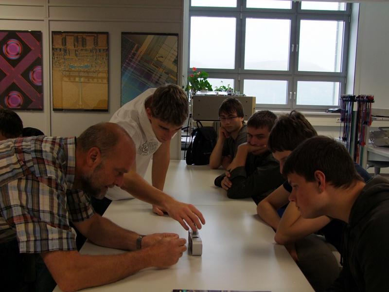 Die Uhr läuft mit Wasser und Salz - Schüler aus Zeulenroda und Zöllnitz untersuchen gemeinsam mit Prof. Dr. Thomas Reuter (links) den Betrieb einer Uhr mittels elektrolytischer Batterie